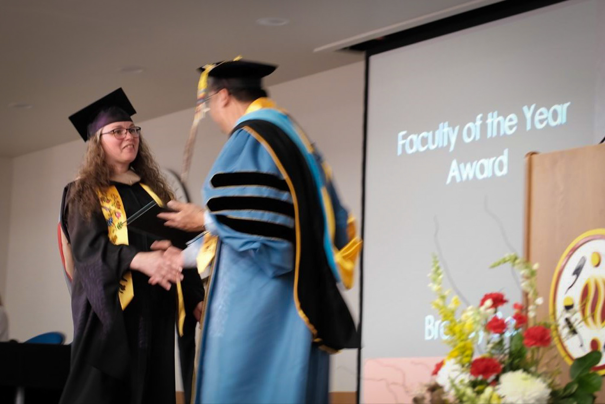 President Dr. Duane Bedell delivering the Faculty of the Year award to Brandy Ball